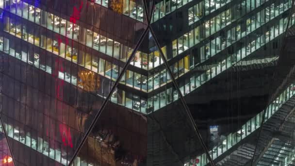 Ventanas en el exterior del edificio de gran altura al final de la noche con luces interiores en timelapse — Vídeos de Stock