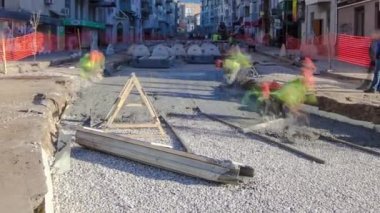 Beton, yol bakımı şantiyesinde çok sayıda işçi ve karıştırıcı zaman ayarlarıyla çalışıyor.