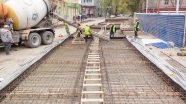 Beton, yol bakımı şantiyesinde çok sayıda işçi ve karıştırıcı zaman ayarlarıyla çalışıyor.