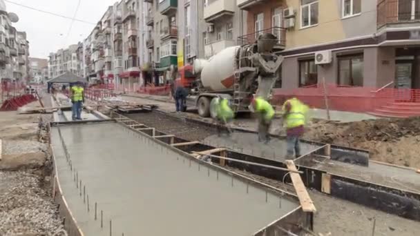 Betonnen werken voor wegenonderhoud bouwplaats met veel werknemers en mixer timelapse — Stockvideo