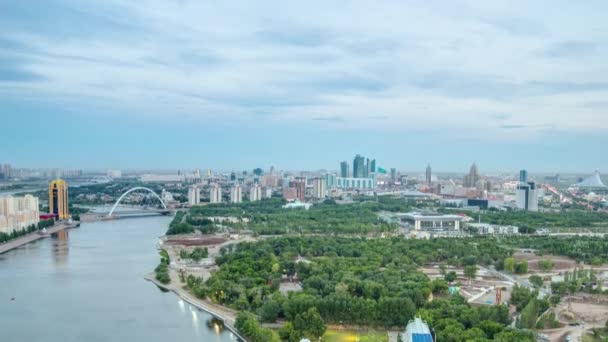 Піднятий погляд над центром міста річкою, парком і центральним діловим районом від вечора до ночі Тімелапс, Казахстан, Астана — стокове відео