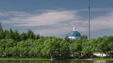 nehir Ishim timelapse, Bina, Bina, tratuar ve park ağaçlarda. Güneşli bir gün. Astana, Kazakistan
