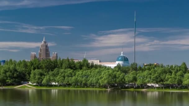 Река Ишим Timelapse, здания, помещения, тратуар и деревья в парке. Солнечный день. Астана, Казахстан — стоковое видео