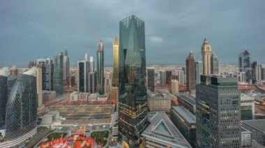 Dubai 'deki finans bölgesi iş merkezindeki fütüristik gökdelenlerin panoraması gece gündüz