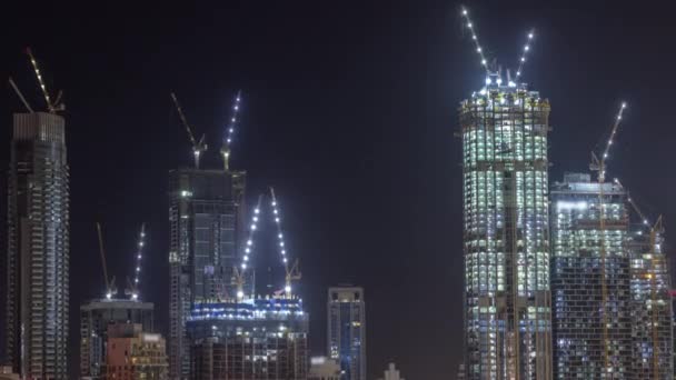 Edifícios de vários andares altos em construção e guindastes à noite timelapse — Vídeo de Stock