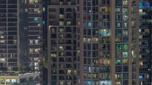 Большие светящиеся окна в современных жилых зданиях по ночам — стоковое видео
