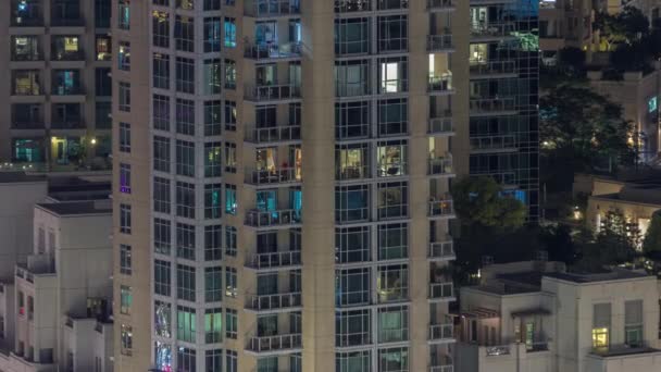Grandes ventanas brillantes en oficinas modernas y edificios residenciales timelapse por la noche — Vídeos de Stock