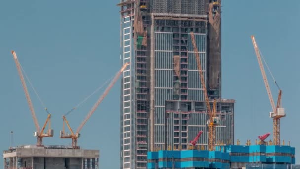 Высокие многоэтажные строящиеся здания и чередующиеся краны — стоковое видео