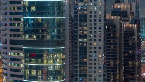 Великі сяючі вікна в сучасних офісних та житлових будівлях вночі — стокове відео