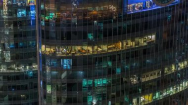 Modern ofiste büyük parlayan pencereler ve gece vakti konut binaları.