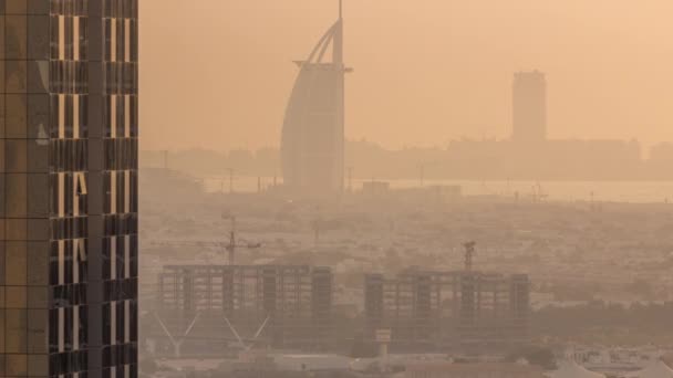 Pohled na staveniště, vily a slavný hotel v obzoru linie z Dubaj Vodní kanál během západu slunce vzdušného času — Stock video