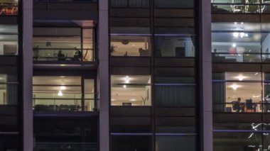 Modern ofiste büyük parlayan pencereler ve gece vakti konut binaları.