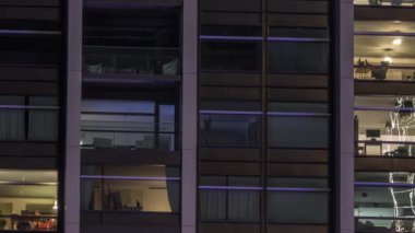 Modern ofiste büyük parlayan pencereler ve gece vakti konut binaları.