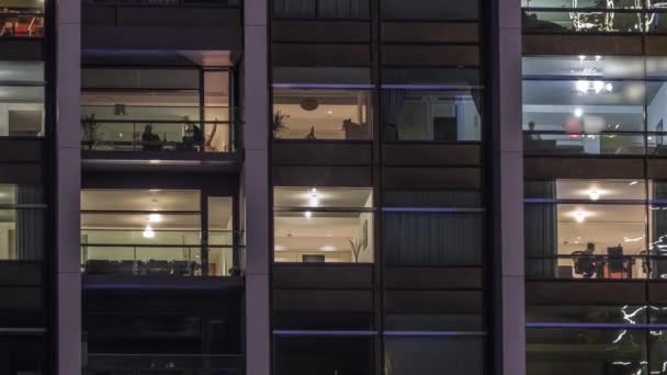 Nagy világító ablakok a modern irodaházak és lakóépületek timelapse éjjel — Stock videók