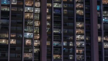 Modern ofiste büyük parlayan pencereler ve gece vakti konut binaları.