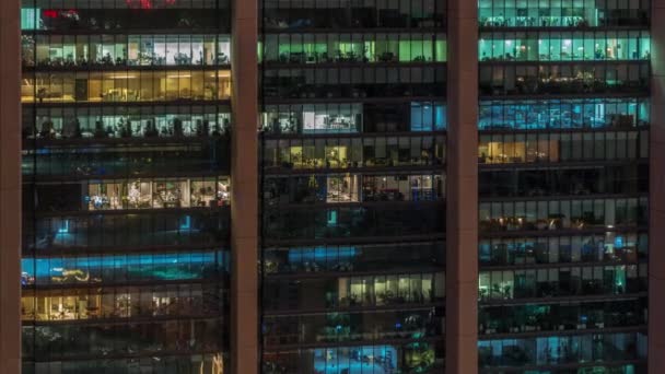 Большие светящиеся окна в современных офисных зданиях по ночам — стоковое видео