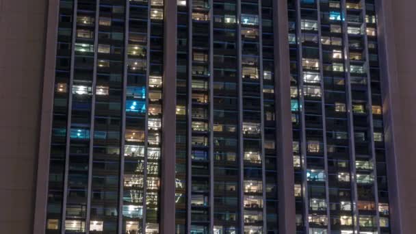 Grandes janelas brilhantes em escritórios modernos e edifícios residenciais timelapse à noite — Vídeo de Stock