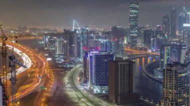 Dubai iş sahası kulelerinin modern mimarisine sahip Skyline gece zaman çizelgesi. Hava görünümü