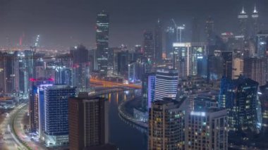Dubai iş sahası kulelerinin modern mimarisine sahip Skyline gece zaman çizelgesi. Hava görünümü