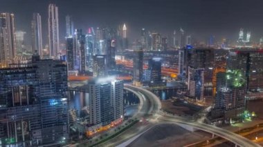 Dubai iş sahası kulelerinin modern mimarisine sahip Skyline gece zaman çizelgesi. Hava görünümü