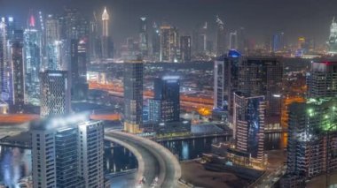 Dubai iş sahası kulelerinin modern mimarisine sahip Skyline gece zaman çizelgesi. Hava görünümü