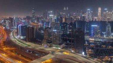 Dubai iş sahası kulelerinin modern mimarisine sahip Skyline gece zaman çizelgesi. Hava görünümü