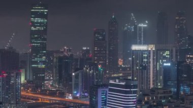 Dubai iş sahası kulelerinin modern mimarisine sahip Skyline gece zaman çizelgesi. Hava görünümü
