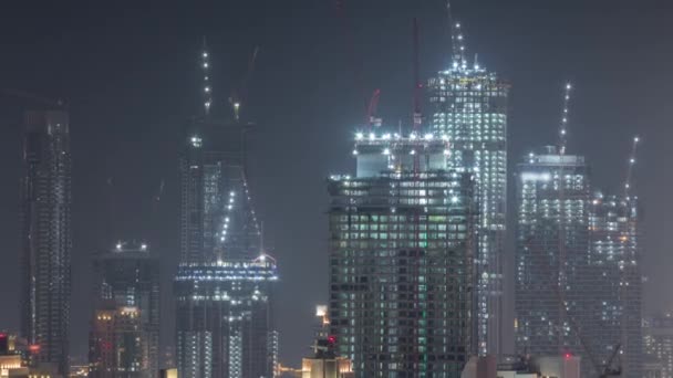 Bâtiments de plusieurs étages en construction et grues la nuit timelapse — Video