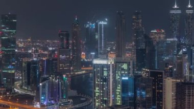 Dubai iş sahası kulelerinin modern mimarisine sahip Skyline gece zaman çizelgesi. Hava görünümü