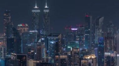 Dubai iş sahası kulelerinin modern mimarisine sahip Skyline gece zaman çizelgesi. Hava görünümü