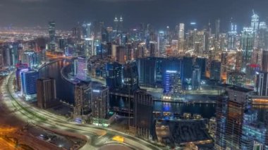 Dubai iş sahası kulelerinin modern mimarisine sahip Skyline gece zaman çizelgesi. Hava görünümü
