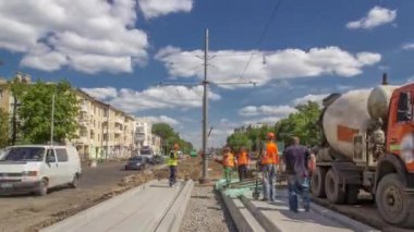 Kalıplar arasında beton dökülüyor yol onarım inşaatı için çok sayıda işçi ve karıştırıcı zaman dilimi ile