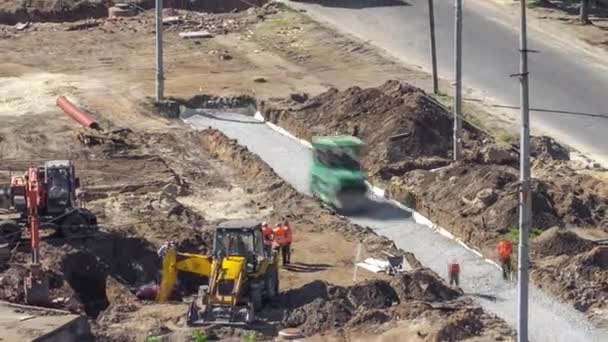 Green vibration roller compactor rolls on a stones at road construction and repariring timelapse — Stok Video