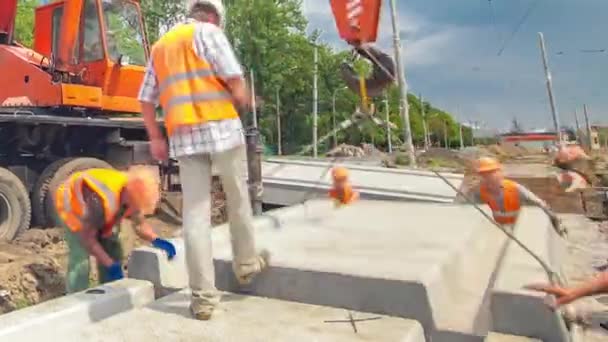 Установка бетонных плит с помощью крана на месте строительства дорог . — стоковое видео