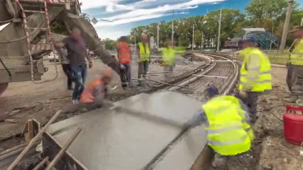 Betongarbeten för vägkonstruktion med många arbetare och mixer timelapse hyperlapse — Stockvideo