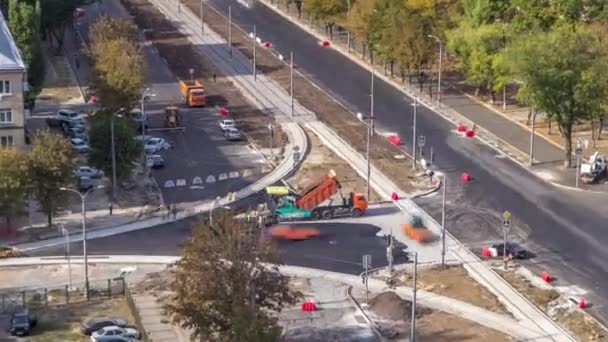 Estaleiro de construção de avenida com asfalto paver, rolo e caminhão aéreo timelapse. — Vídeo de Stock