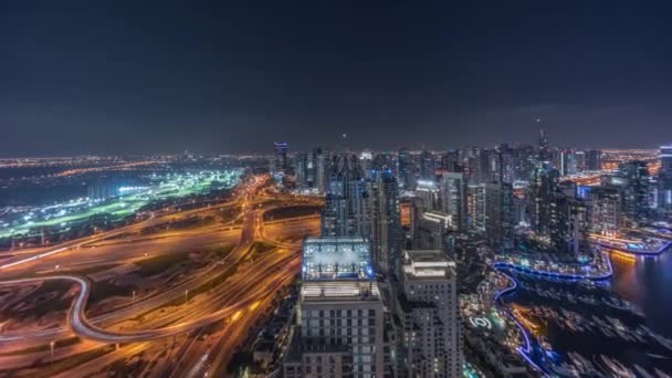 Dubai jachthaven en JLT wolkenkrabbers langs Sheikh Zayed Road luchtfoto nachtelijke tijdspanne. — Stockvideo