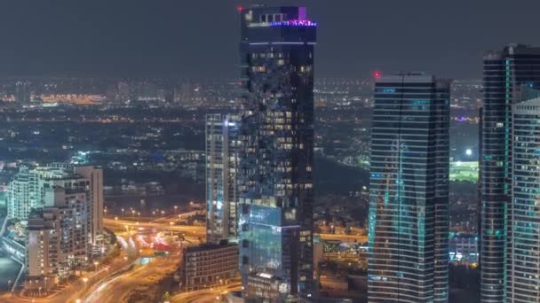 JLT skyscrapers near Sheikh Zayed Road aerial night timelapse. Residential buildings and villas behind — Stock Video