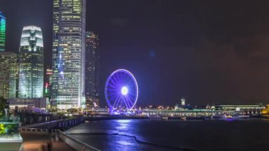 Skycrapers gece timelapse ve kentin en son turist çeken Hong Kong gözlem tekerleği.