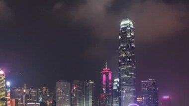 Bulutlu gökyüzü ve kentsel gökdelenler zaman aşımı hiperlapse ile Victoria Harbor üzerinde gece Hong Kong şehir silueti.