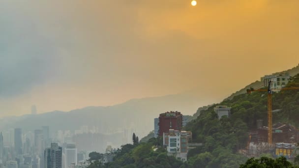 Знаменитый вид Гонконга из окна отеля Victoria Peak. Снято на рассвете, пока солнце поднимается над холмом в заливе Коулун . — стоковое видео
