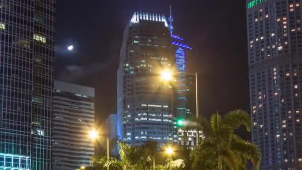 Hyperlapsus nocturne de la ville moderne dans le parc avec fontaine et gratte-ciel autour. Temps écoulé. Hong Kong — Video