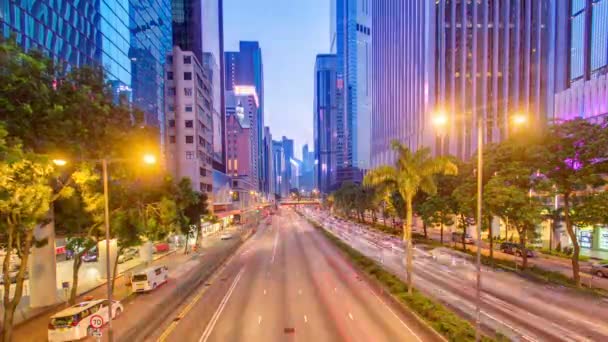 Gece gündüz alacakaranlıkta yoğun trafik ve gökdelen ofisi ile Hong Kong sokak. — Stok video