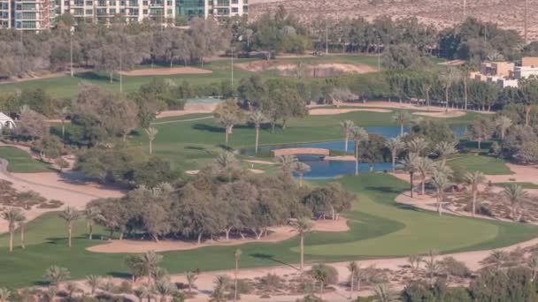 Lucht uitzicht op golfbaan met groene gazon en meren, villa huizen erachter timelapse. — Stockvideo