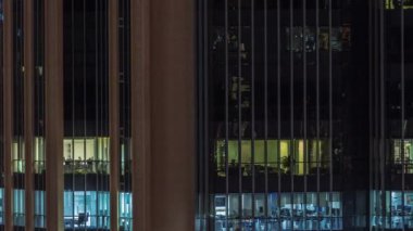 Modern ofis binalarındaki pencere ışıkları geceleri zaman ayarlı