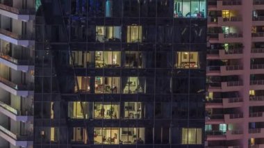 Modern ofisteki pencere ışıkları ve konut binaları geceleri zaman ayarlı