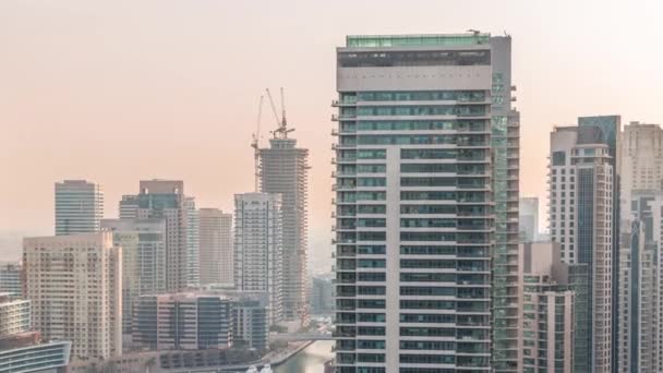 Vista aérea de los rascacielos del puerto deportivo de Dubai alrededor del canal con timelapse de barcos flotantes — Vídeos de Stock