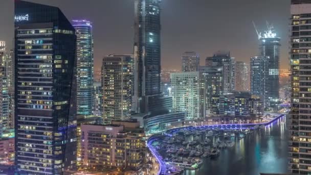 环绕着运河的迪拜码头摩天大楼的空中景观，浮动的船在深夜掠过 — 图库视频影像
