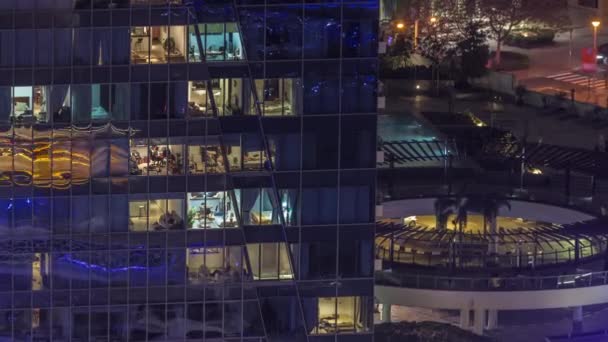 Modern ofisteki pencere ışıkları ve konut binaları geceleri zaman ayarlı — Stok video