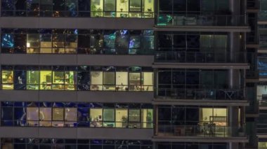 Modern ofisteki pencere ışıkları ve konut binaları geceleri zaman ayarlı